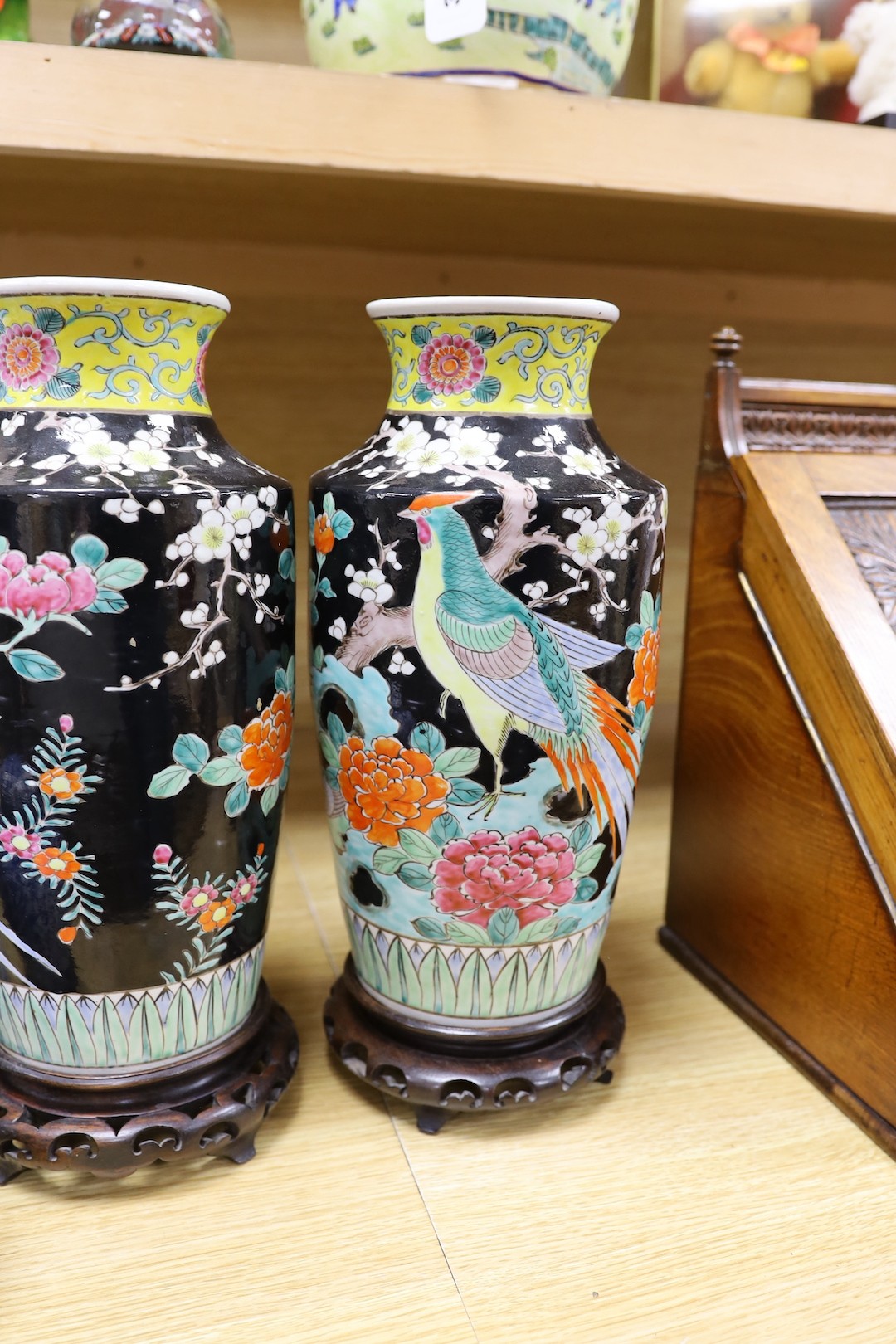 A pair of Japanese black ground vases, a pair of Chinese blue and white vases and covers, a similar pair of jars and a vase, four wood stands. Largest 41cm